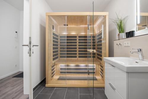 a glass shower in a bathroom with a sink at Weiße Villen Weiße Villen 1-11 in Boltenhagen