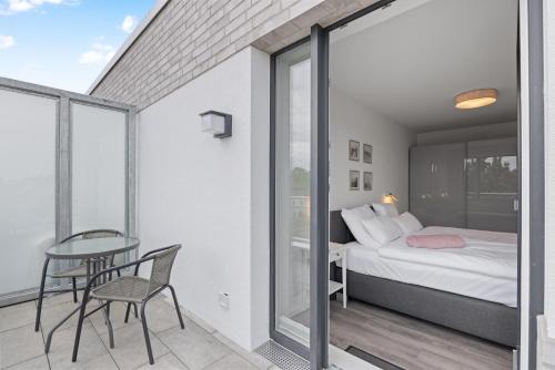 Un dormitorio con una cama y una mesa en el balcón. en Weiße Villen Weiße Villen 1-11, en Boltenhagen