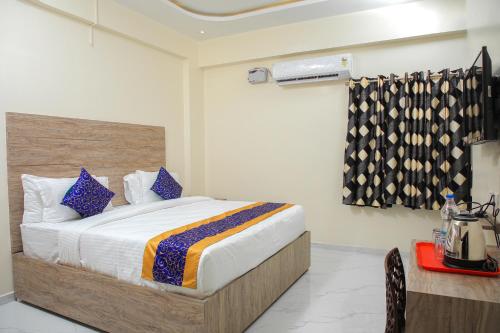 um quarto com uma cama grande e almofadas azuis em Redstone Service Apartment-TNagar Near USConsulate em Chennai