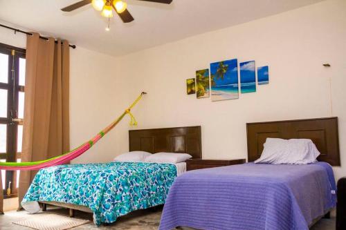 um quarto com 2 camas e uma rede de descanso em Casa Flamingos Altabi em Mérida