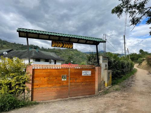 a wooden fence with a wooden gate in front of a house at Cabaña Campestre Miraluna in Choachí