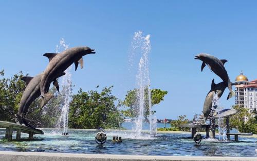 a fountain with dolphins jumping in the water at Luxury 3BD house, Siesta Key Beach in Sarasota