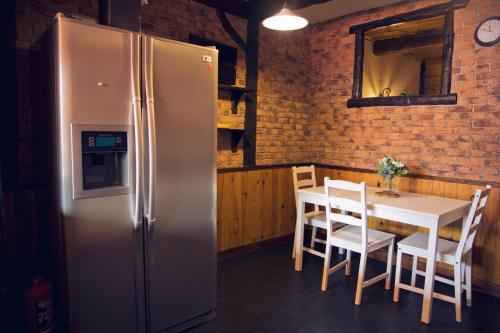 eine Küche mit einem Kühlschrank und einem Tisch mit Stühlen in der Unterkunft Amumamaria_ vt in Bermeo