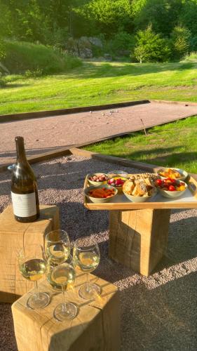 - une table avec un plateau de nourriture et des verres à vin dans l'établissement Domaine du Chant de la Planche - SPA - Hautes Vosges, à Saulxures-sur-Moselotte