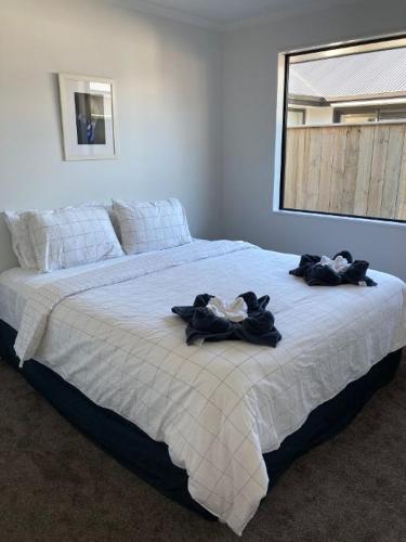 a bedroom with a large bed with towels on it at Brand new family home in Richmond