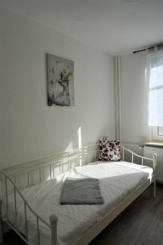 ein weißes Bett in einem Schlafzimmer mit Fenster in der Unterkunft Ferienwohnung TrautesHeim - Parkplatz gratis in Ilmenau