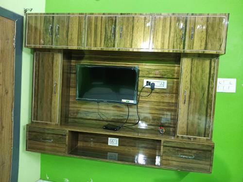 a wooden entertainment center with a tv on a wall at Trinetra Inn in Varanasi