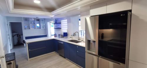 a kitchen with blue cabinets and a stainless steel refrigerator at Luxury 3BD house, Siesta Key Beach in Sarasota