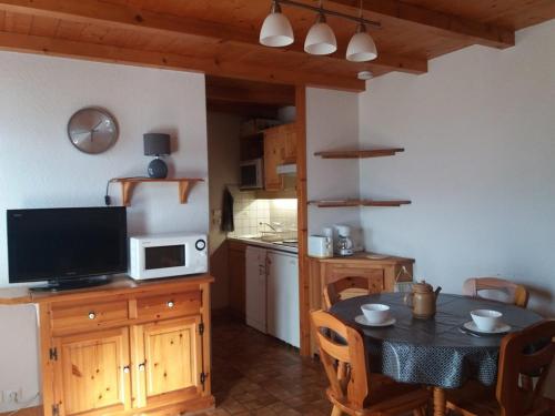 une cuisine avec une table, une télévision et une salle à manger dans l'établissement Appartement cozy 4 pers, 2 chambres, proche pistes et commerces, balcon, parking, animaux acceptés - FR-1-733-10, à Crest-Voland