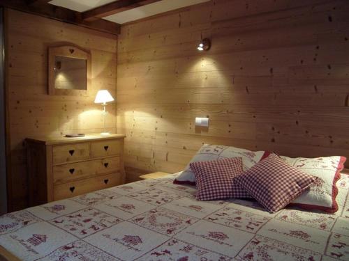 une chambre avec un lit et un mur en bois dans l'établissement Chalet spacieux pour 10 pers. avec garage, proche pistes - FR-1-733-7, à Crest-Voland