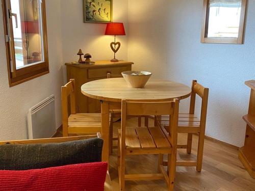 - une table à manger avec des chaises et un bol dans l'établissement Appartement cosy pour 4 avec WiFi proche pistes et commerces - FR-1-733-93, à Crest-Voland