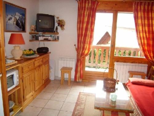 un salon avec un canapé et une télévision dans l'établissement Charmant appartement 2P pour 5 pers, à deux pas des pistes, balcon, cuisine équipée, parking, animaux ok - FR-1-733-90, à Crest-Voland