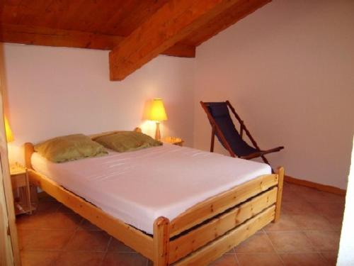 une chambre avec un grand lit et une chaise dans l'établissement Duplex agréable 8 pers à 100m des pistes - FR-1-733-95, à Crest-Voland