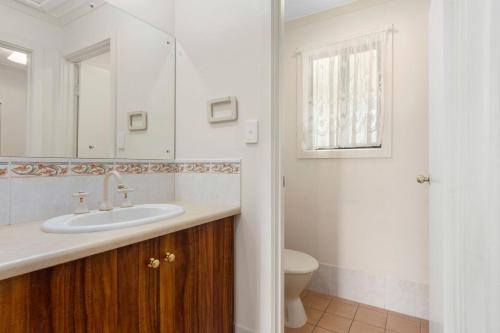 a bathroom with a sink and a toilet and a mirror at Pascalinga 38 Carrickalinga Road in Carrickalinga
