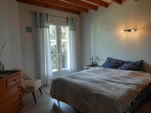 une chambre avec un lit, une fenêtre et une chaise dans l'établissement Maison 4 chambres avec jardin clos, proche plage et centre, à Vieux-Boucau - FR-1-239-964, à Vieux-Boucau-les-Bains
