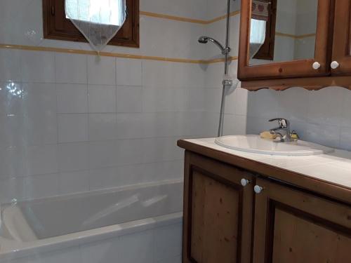 une salle de bain avec un lavabo et une baignoire dans l'établissement Appartement 6 pers. Rez-de-chaussée avec piscine et parking - FR-1-733-125, à Crest-Voland
