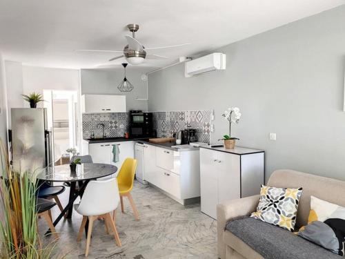 une cuisine et un salon avec un canapé et une table dans l'établissement T2 rénové, climatisé au cœur de la Favière avec parking et terrasse/jardinet exposés Sud-Est. - FR-1-610-87, à Bormes-les-Mimosas