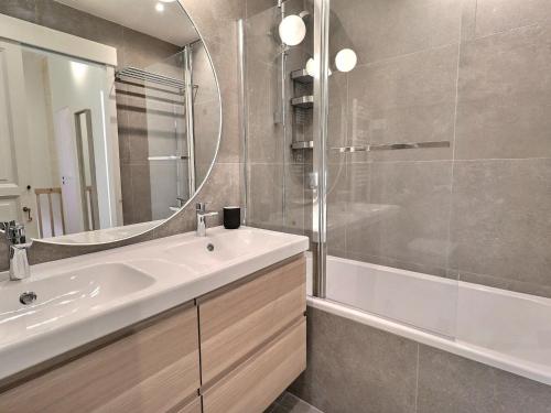 une salle de bain avec un lavabo, un miroir et une baignoire dans l'établissement Superbe Duplex Rénové 3* - Lumineux, Skis aux Pieds - 8 Pers, 62m², 5 Pièces, Balcon Sud - FR-1-182-254, à Les Allues