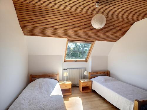 deux lits dans une chambre avec un plafond en bois dans l'établissement Villa en bord de mer à Jullouville, accès direct plage, 6 chambres, jardin et barbecue - FR-1-361-496, à Jullouville