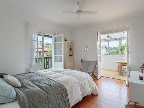 une chambre blanche avec un grand lit et une table dans l'établissement Spacieux appart 3* à Biarritz, proche commerces, plage et centre, avec wifi et balcon - FR-1-3-589, à Biarritz