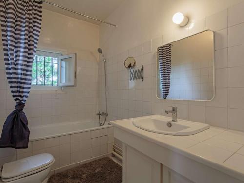 une salle de bain avec un lavabo, des toilettes et un miroir dans l'établissement Spacieux appart 3* à Biarritz, proche commerces, plage et centre, avec wifi et balcon - FR-1-3-589, à Biarritz