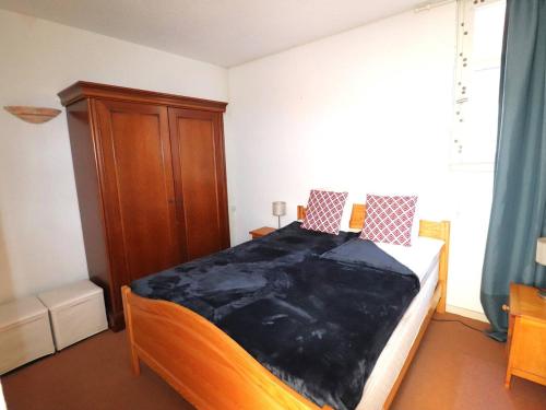 1 dormitorio con 1 cama y armario de madera en Appartement Le Grau-du-Roi, 2 pièces, 4 personnes - FR-1-307-240, en Le Grau-du-Roi
