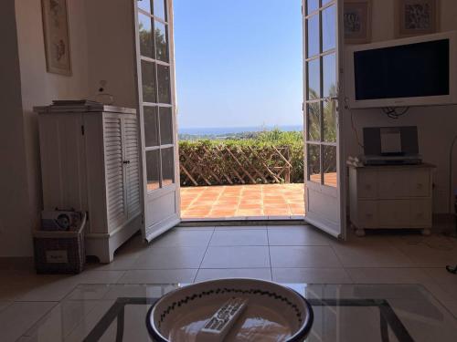 - un salon avec une porte s'ouvrant sur une terrasse dans l'établissement Mas 3 chambres avec piscine, clim, Wi-Fi et tennis - FR-1-726-29, à La Croix-Valmer