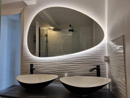 une salle de bain avec deux lavabos et un grand miroir dans l'établissement Appartement rénové 2 chambres avec clim, wifi, et parking à Cavalaire-sur-Mer - FR-1-100-308, à Cavalaire-sur-Mer