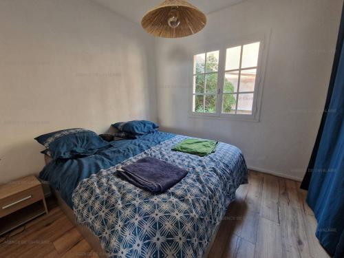 une chambre avec un lit avec une couette bleue et une fenêtre dans l'établissement Appartement rénové 2 chambres avec clim, wifi, et parking à Cavalaire-sur-Mer - FR-1-100-308, à Cavalaire-sur-Mer