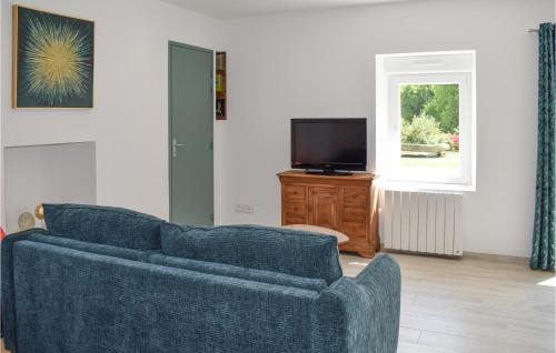 a living room with a blue couch and a tv at Awesome Home In Canihuel in Canihuel