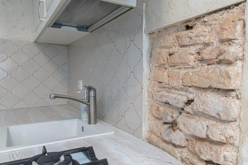 a kitchen with a sink and a brick wall at Luxury apartment in Pilies street in Vilnius