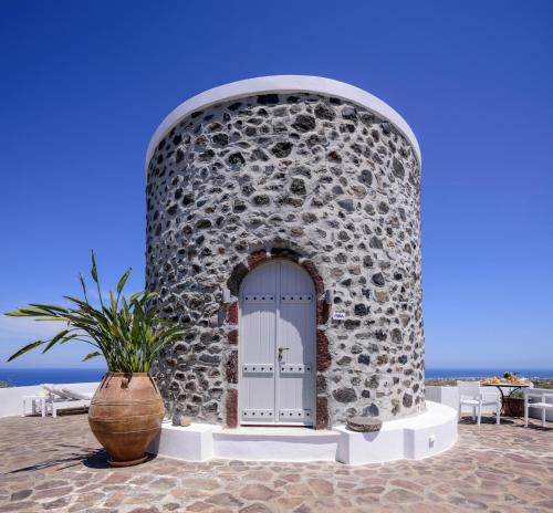 a door in a stone wall with a plant in front at CASA ARISTA in Fira