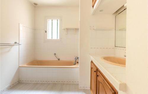 uma casa de banho com uma banheira e um lavatório em Amazing Home In Graveson With Kitchen em Graveson
