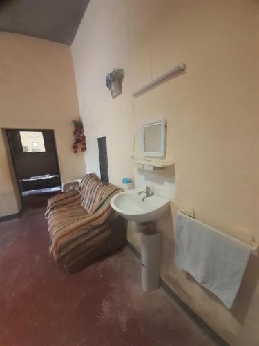 a bathroom with a couch and a sink in it at Maison berbère in Ouarzazate