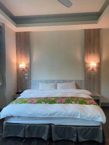 a bedroom with a large bed with flowers on it at 南庄蔓森活Nan Juang Man Son Living in Nanzhuang