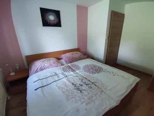 a bedroom with a bed with a white comforter at Apartmaji Mojca in Bohinj