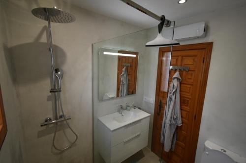 a bathroom with a sink and a shower and a mirror at Casa Maya in Benissa