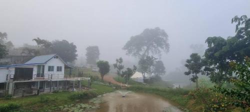 een huis en een vijver voor een huis bij เขาเจ้าขา2(บ้านริมสระ) in Khao Kho