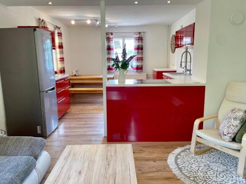 uma cozinha e uma sala de estar com armários vermelhos em Lendorfer Cottage em Feldkirchen in Kärnten