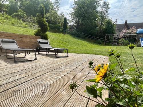 a wooden deck with two chairs and a bench at Lendorfer Cottage in Feldkirchen in Kärnten