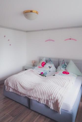 a bedroom with a white bed with pink pillows at Dreierzimmer in Därligen
