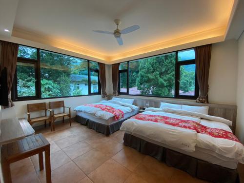 南庄的住宿－南庄蔓森活Nan Juang Man Son Living，带大窗户的客房内的两张床