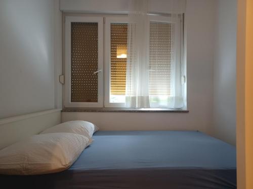 een bed in een kamer met een raam bij Apartment Penny in Split