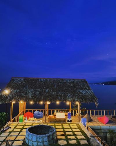 um resort com uma fogueira e um telhado de palha em Casay Beach Huts by HiveRooms em Dalaguete
