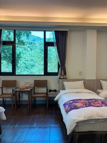 a bedroom with a bed and a large window at 南庄蔓森活Nan Juang Man Son Living in Nanzhuang