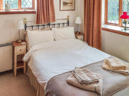 a bedroom with a bed with two towels on it at Hunt Cottage in Sharrington