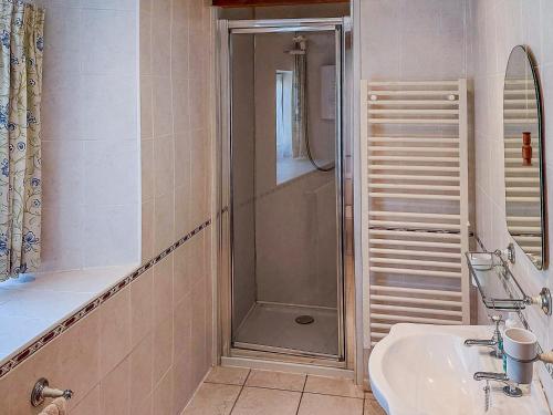 a bathroom with a shower and a sink at Hunt Cottage in Sharrington