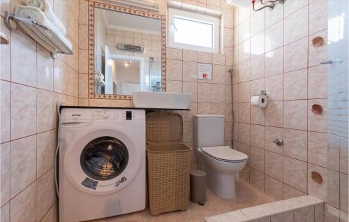 a bathroom with a washing machine and a toilet at Nice Apartment In Komarna With Wifi in Klek