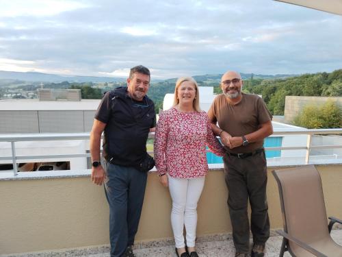 a group of three people standing on a balcony at Pensión Casa do Gallo Sarria in Sarria