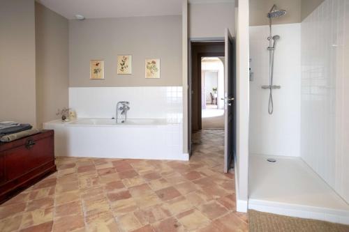 bagno con vasca e lavandino di Maison d'hôtes ÔVillage a Ouveillan
